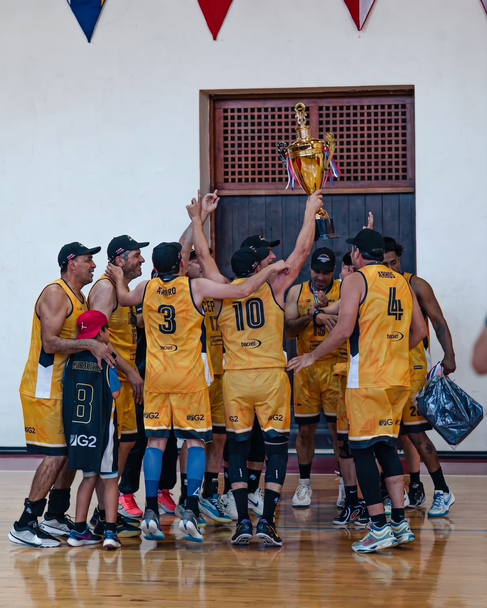 El equipo campeón de la Liga celebrando con la copa en alto en el centro de la cancha.